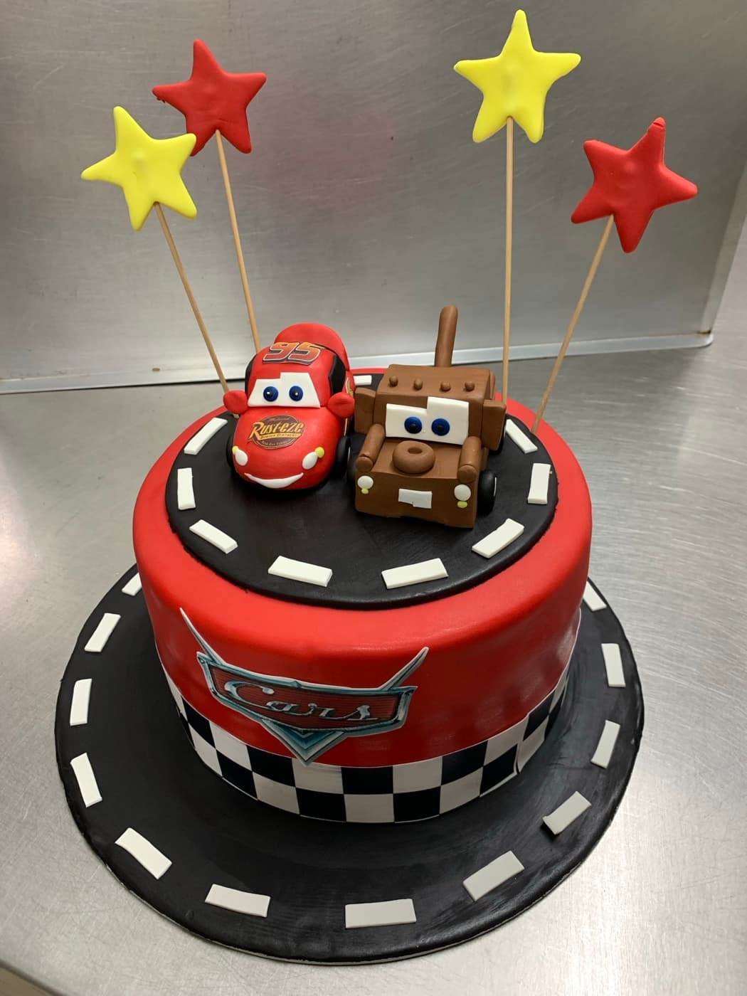 Racing-themed birthday cake with car figures