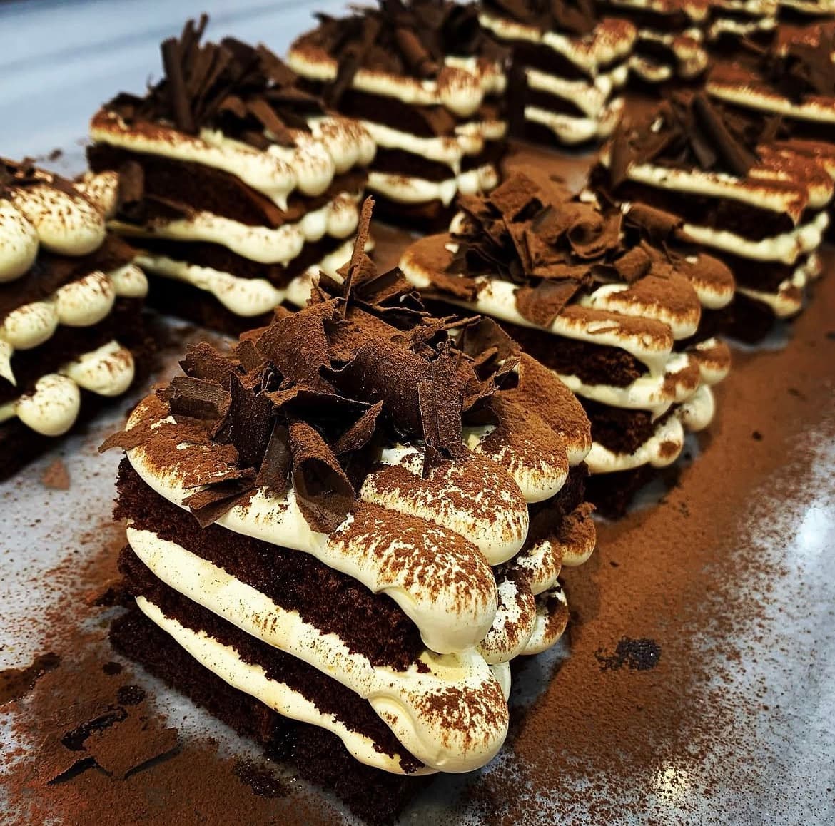 Layered tiramisu-style dessert dusted with cocoa