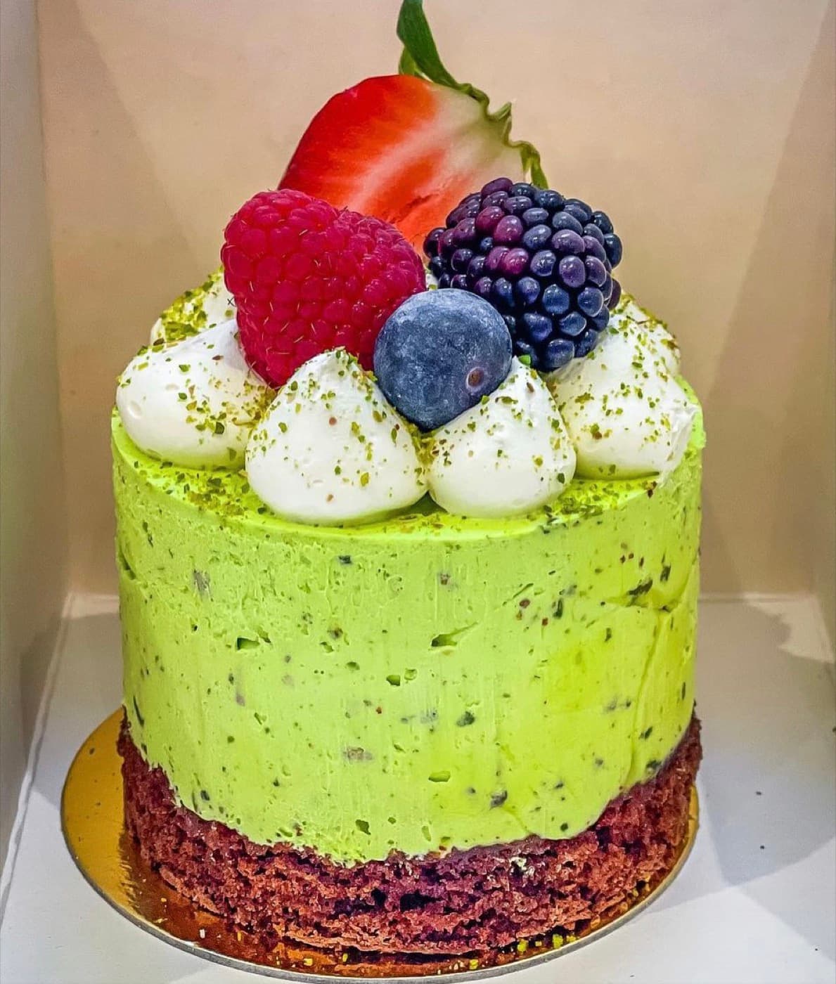 Green mousse cake topped with mixed fresh berries